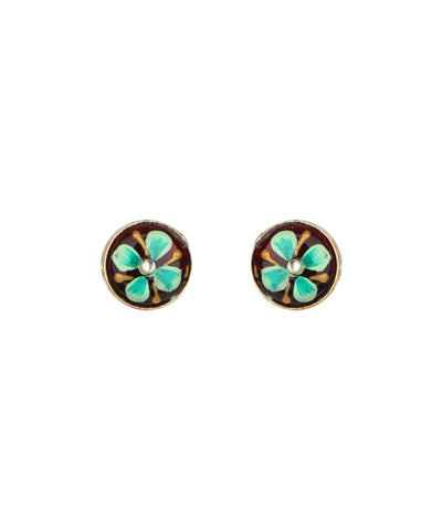 A pair of oval stud earrings featuring a turquoise and gold floral design on a dark brown background, with a small clear stone at the center of each.